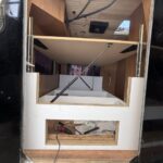 Bed with electric lift mechanism in van